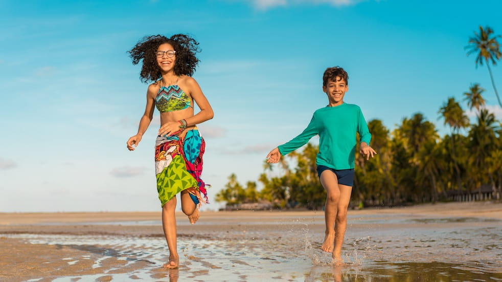 Children running on Carneiros Beach in Tamandaré, Pernambuco, Brazil 